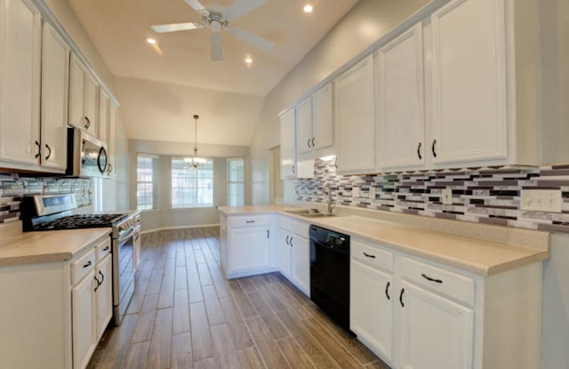 kitchen with lofted ceiling, stainless steel appliances, hardwood / wood-style floors, decorative light fixtures, and white cabinets