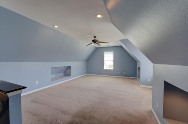 bonus room with light carpet, a textured ceiling, ceiling fan, and vaulted ceiling