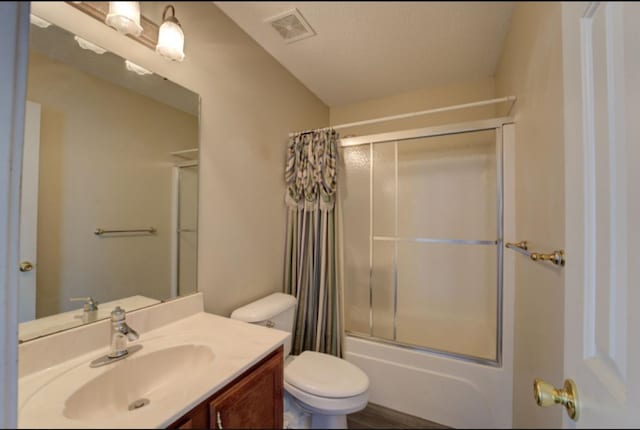 full bathroom featuring vanity, toilet, a textured ceiling, and shower / bath combo