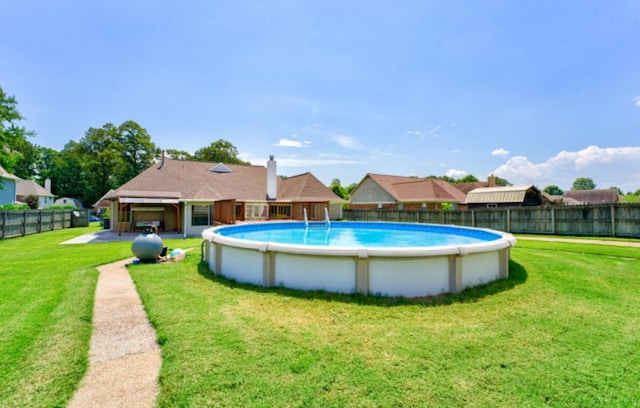 view of swimming pool featuring a yard