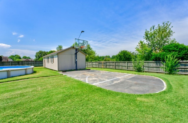 view of sport court with a yard and a fenced in pool