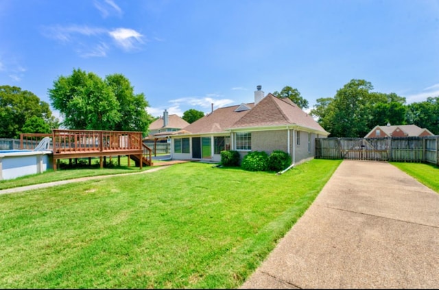 view of front of property featuring a front yard and a wooden deck