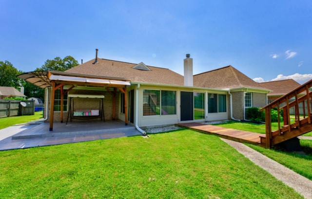 back of property with a patio, a wooden deck, and a lawn