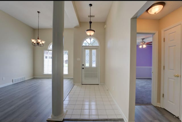 entrance foyer featuring light hardwood / wood-style floors, a healthy amount of sunlight, and ceiling fan with notable chandelier