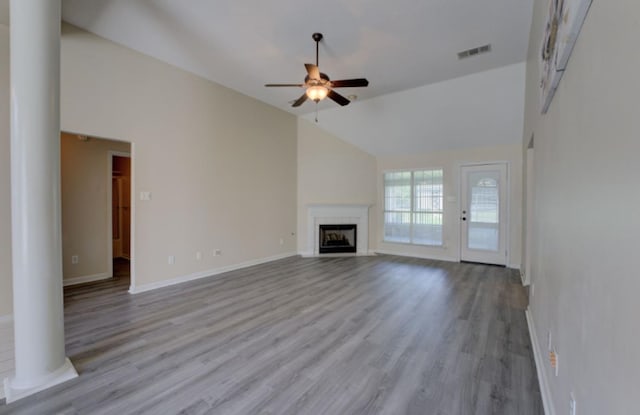 unfurnished living room featuring light hardwood / wood-style flooring, ornate columns, high vaulted ceiling, and ceiling fan