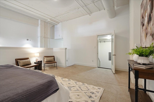 bedroom with a closet, a spacious closet, and light colored carpet