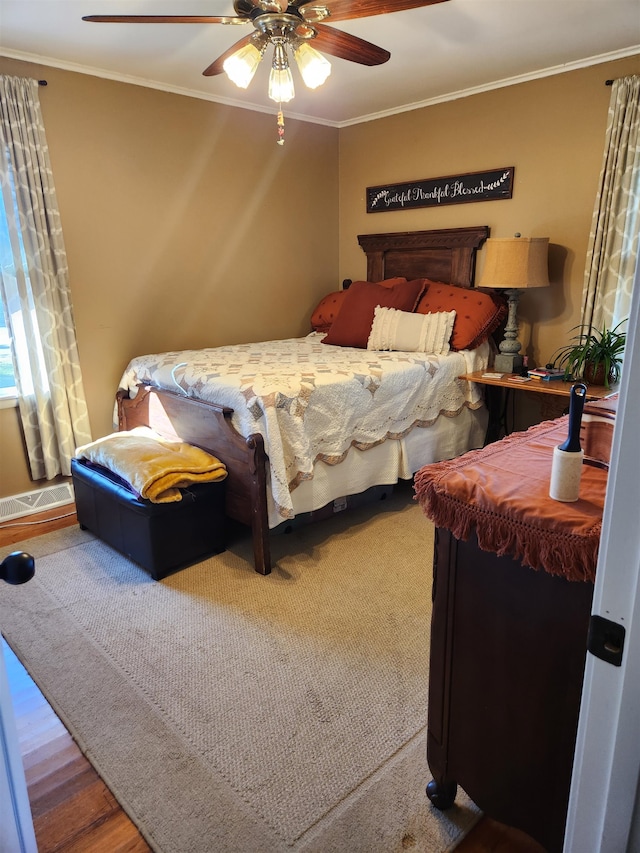 bedroom with crown molding, hardwood / wood-style floors, and ceiling fan