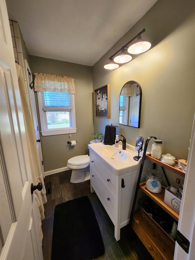 bathroom featuring vanity, wood-type flooring, and toilet