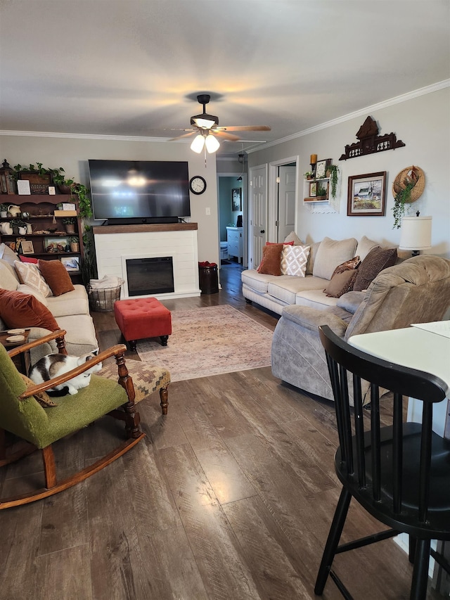 living room with ornamental molding, dark hardwood / wood-style floors, and ceiling fan