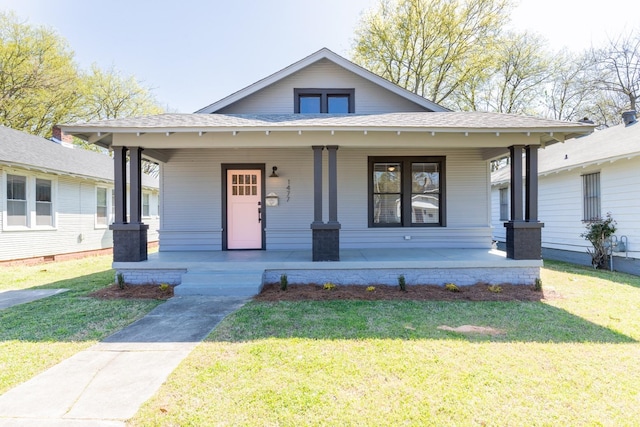 bungalow featuring a porch and a front lawn