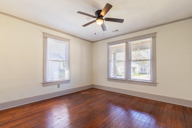 spare room featuring ornamental molding, dark hardwood / wood-style floors, a healthy amount of sunlight, and ceiling fan