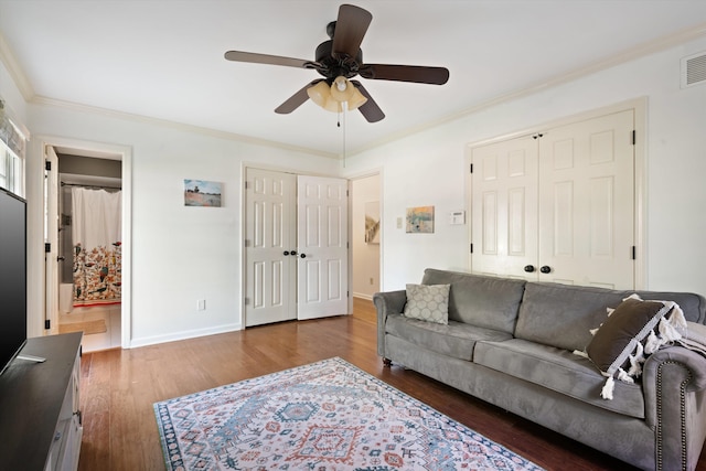 living room featuring crown molding, dark hardwood / wood-style floors, and ceiling fan