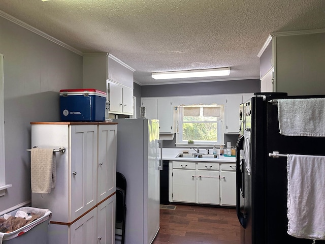 kitchen with dark hardwood / wood-style flooring, white cabinetry, black refrigerator, crown molding, and white refrigerator