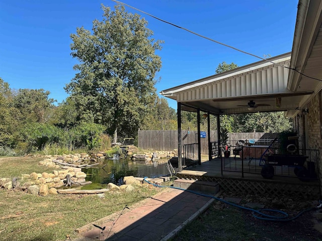 view of yard with a deck and ceiling fan