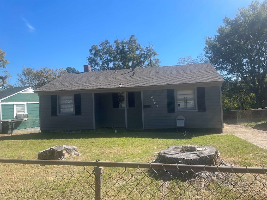 rear view of house featuring cooling unit and a lawn