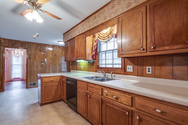 kitchen with sink, black dishwasher, ceiling fan, and wood walls