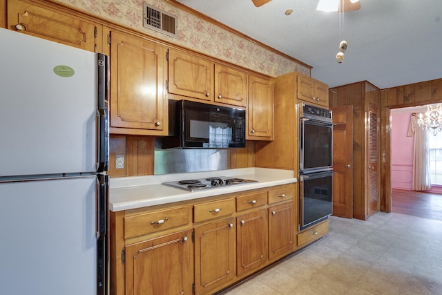 kitchen featuring black appliances, ornamental molding, ceiling fan, and a textured ceiling