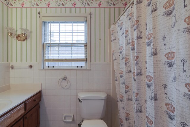 bathroom with vanity, toilet, tile walls, and curtained shower