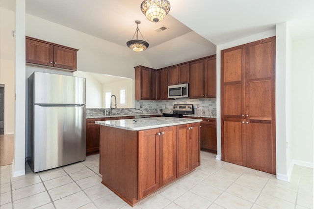 kitchen with a center island, hanging light fixtures, stainless steel appliances, light stone counters, and decorative backsplash