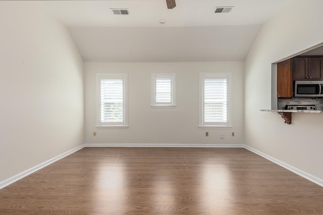 interior space featuring lofted ceiling, hardwood / wood-style flooring, and ceiling fan