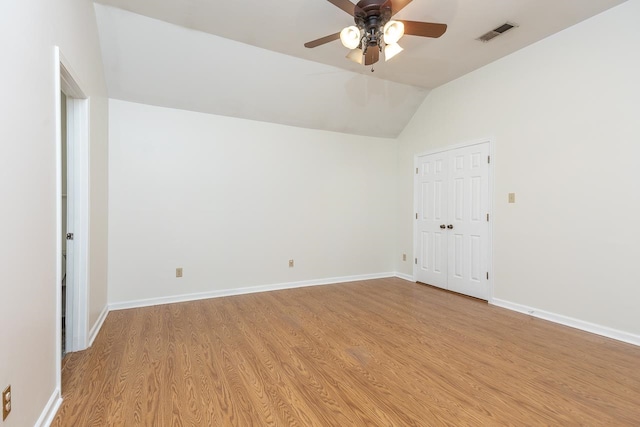 empty room featuring light hardwood / wood-style flooring, ceiling fan, and vaulted ceiling