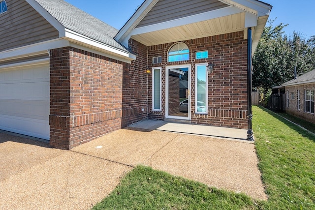 doorway to property with a yard and a garage