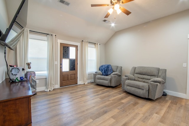 living area with lofted ceiling, light hardwood / wood-style floors, and ceiling fan