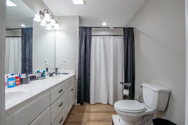 bathroom with toilet, hardwood / wood-style floors, curtained shower, vanity, and a textured ceiling