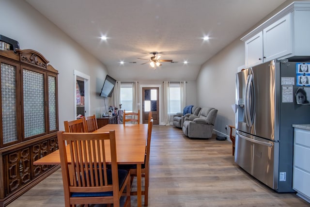 dining room with ceiling fan, lofted ceiling, and light hardwood / wood-style flooring