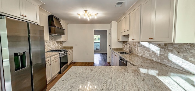 kitchen with appliances with stainless steel finishes, light stone countertops, custom range hood, dark wood-type flooring, and sink