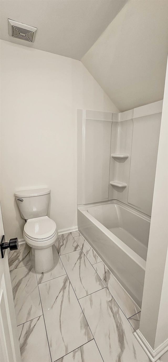 bathroom with vaulted ceiling, toilet, and shower / bathtub combination