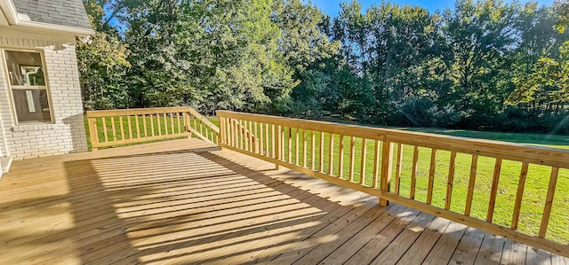 wooden terrace featuring a lawn