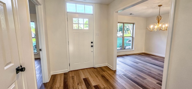 foyer entrance with hardwood / wood-style flooring and an inviting chandelier