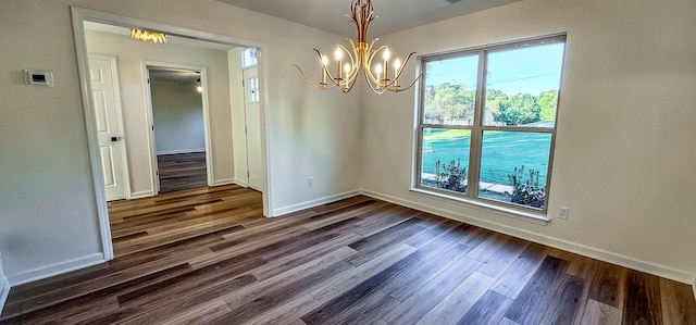 unfurnished dining area with a notable chandelier and dark hardwood / wood-style flooring