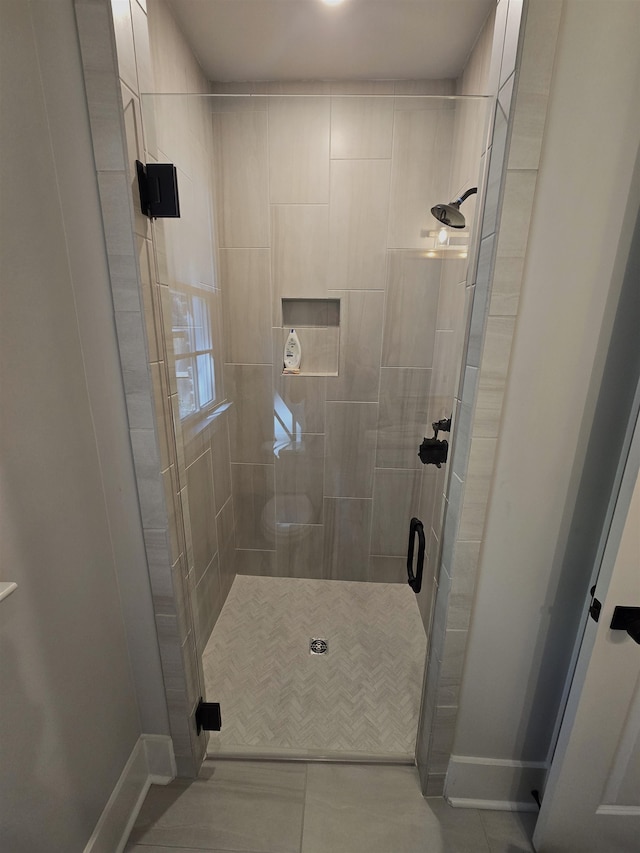 bathroom featuring an enclosed shower and tile patterned floors