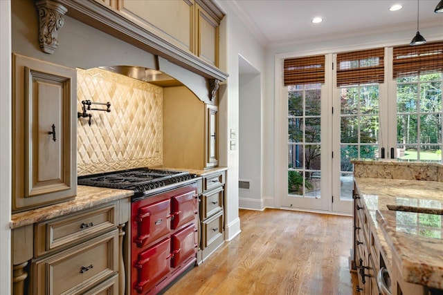 kitchen with light stone counters, crown molding, and light hardwood / wood-style flooring