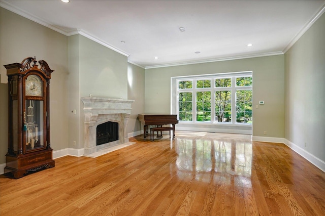 unfurnished living room with a premium fireplace, light hardwood / wood-style flooring, and ornamental molding