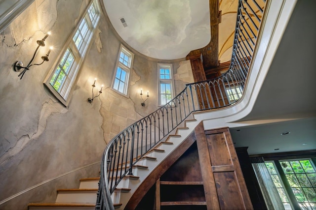 stairway with a wealth of natural light and a high ceiling