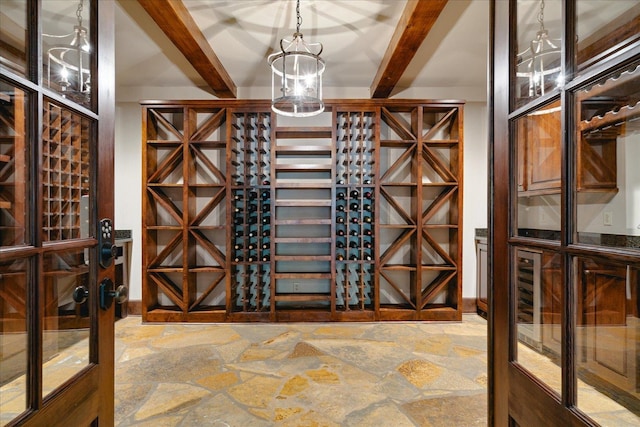 wine cellar featuring an inviting chandelier and beam ceiling