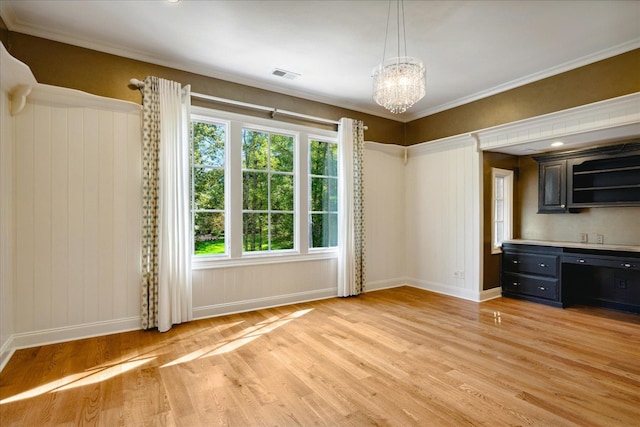 interior space featuring light hardwood / wood-style floors, an inviting chandelier, and ornamental molding