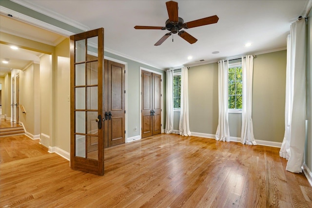 spare room with french doors, light hardwood / wood-style floors, crown molding, and ceiling fan