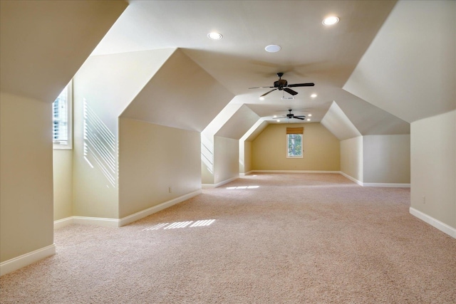 additional living space with ceiling fan, a wealth of natural light, and light colored carpet