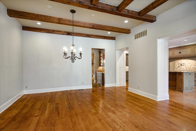 unfurnished room featuring beam ceiling, a chandelier, and light hardwood / wood-style flooring