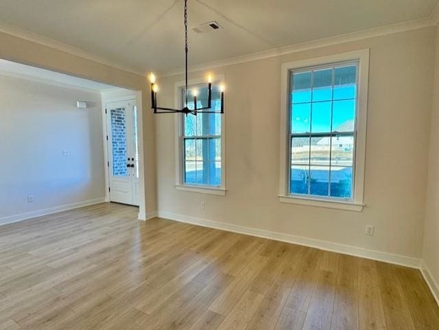 unfurnished dining area with hardwood / wood-style floors, ornamental molding, and an inviting chandelier