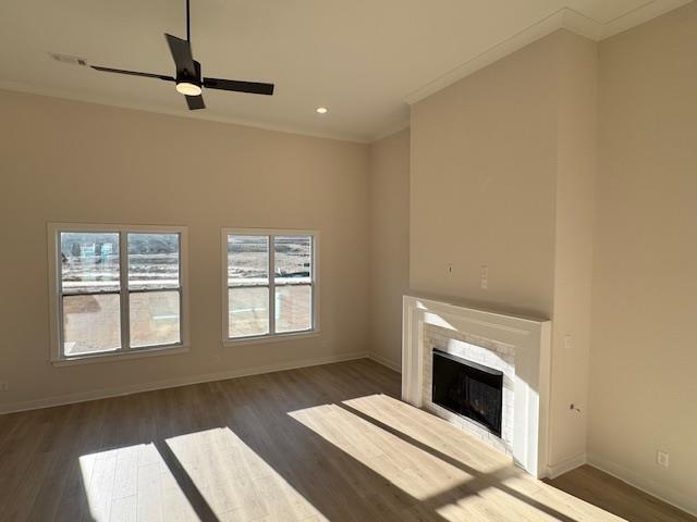 unfurnished living room with dark hardwood / wood-style flooring, crown molding, and a fireplace