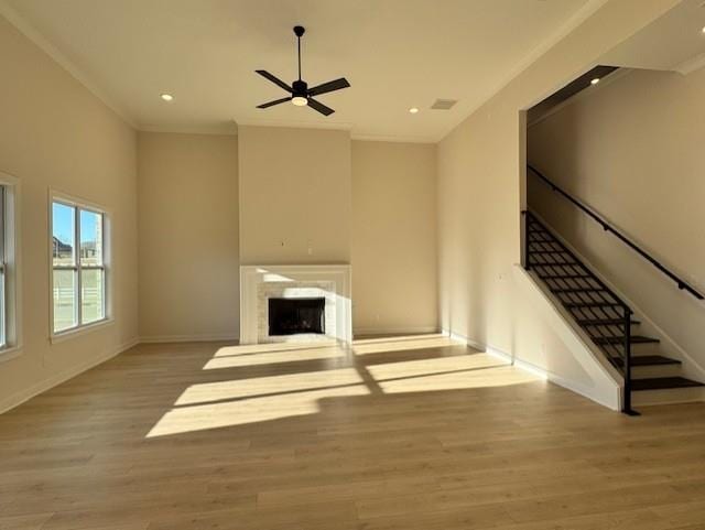 unfurnished living room with ceiling fan, light hardwood / wood-style flooring, and ornamental molding