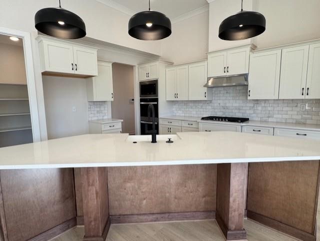 kitchen with decorative light fixtures, a spacious island, and white cabinetry