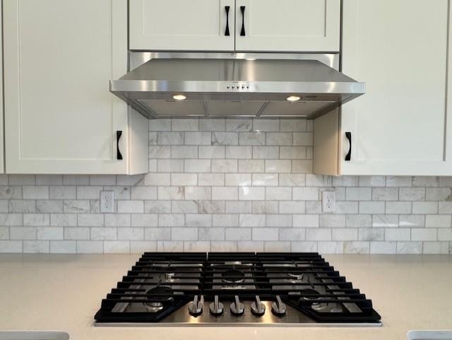 kitchen with white cabinetry, backsplash, and extractor fan