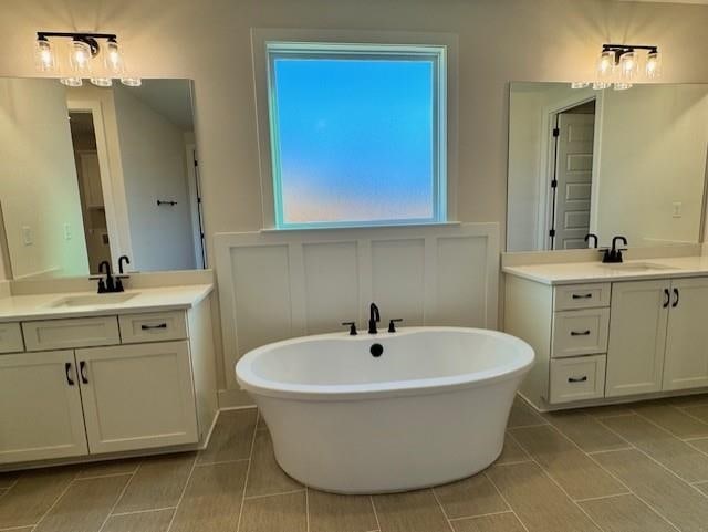 bathroom featuring a tub to relax in, vanity, and tile patterned flooring