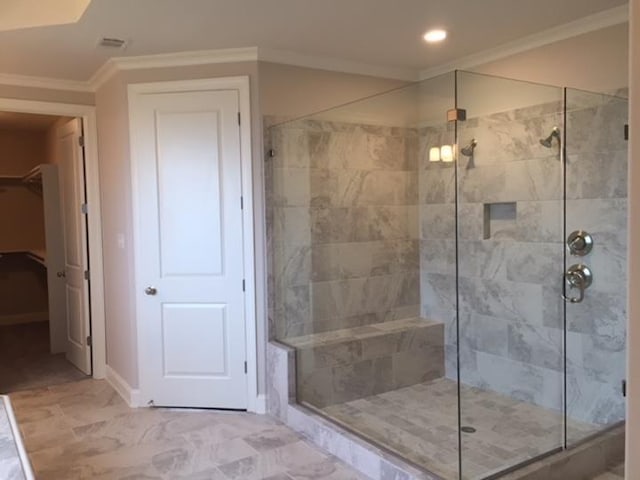 bathroom featuring ornamental molding and a tile shower